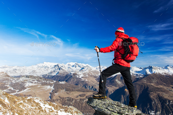 Hiker takes a rest admiring the mountain landscape. - Stock Photo - Images