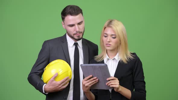 Young Business Couple Using Digital Tablet Together While Having Meeting