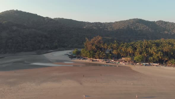 Footage of a beach, at sunset, during a low tide at the tourist destination spot of Palolem, India alt