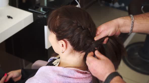 Male Hands of Master Braid Hair of Young Girls