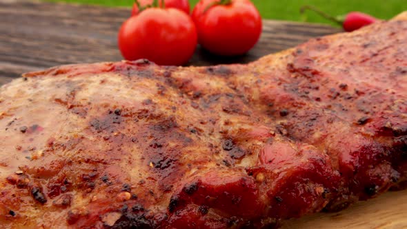 Closeup Panorama of the Juicy Grilled Ribs Laying on the Wooden Board Outdoors alt