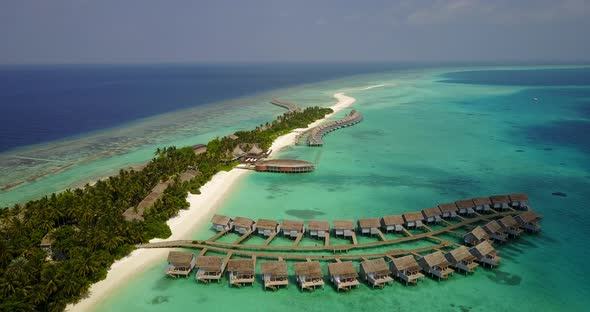 Wide flying travel shot of a paradise sunny white sand beach and aqua blue ocean background  alt