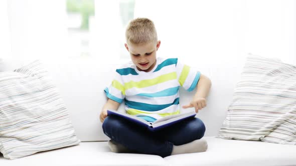 Smiling Little Schoolboy Reading Book At Home 2 alt