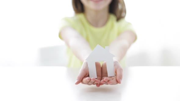 Close-Up Of Smiling Girl Holding Paper House 1 alt