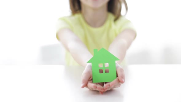 Close-Up Of Smiling Girl Holding Paper House 2 alt