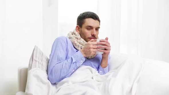 Ill Man With Flu Drinking Hot Tea At Home 1 alt