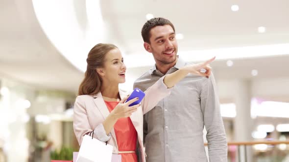 Couple With Smartphone And Shopping Bags In Mall 1 alt