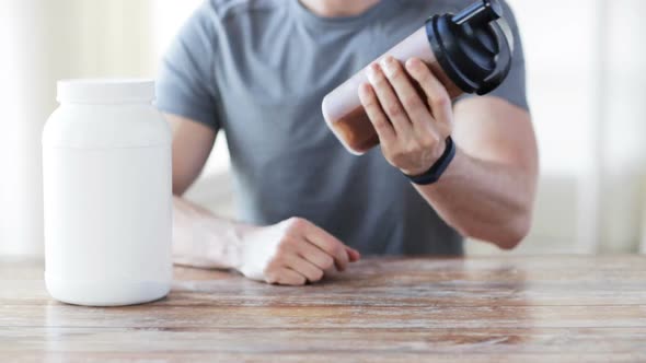 Close Up Of Man With Protein Shake Bottle And Jar 4 alt