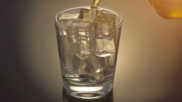 Pouring Scotch Whiskey Over Ice
