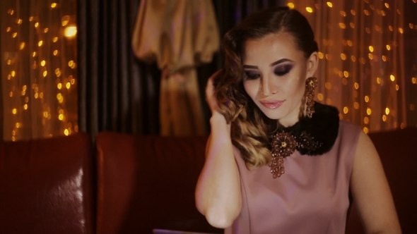 Portrait Of Happy Young Woman Sitting In Modern