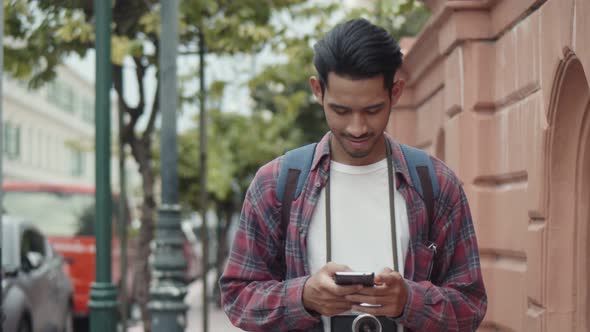 Attractive tourists Asian man using a smartphone checking social media while walking.