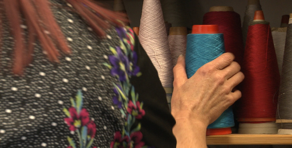 Woman Takes Blue Yarn from Shelf