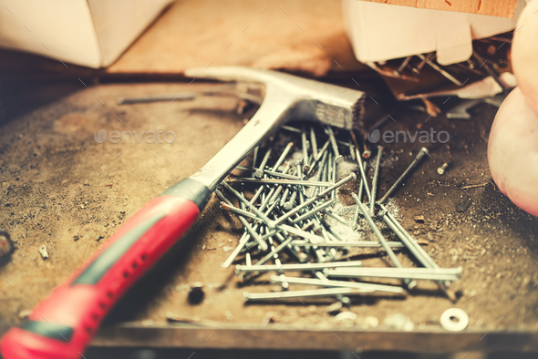 Construction tools, carpentry hammer and nails in work shop. Soft effect on photo