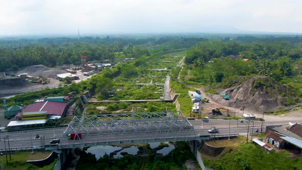 Kali Putih River bridge and dry riverbed overgrown by greenery aerial view alt