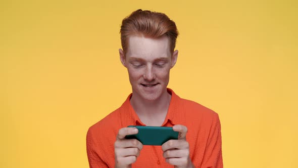 Carefree Man Playing Games on Modern Smartphone alt