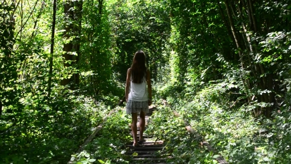 Teenager Girl Walks On Scenic Railway With Green