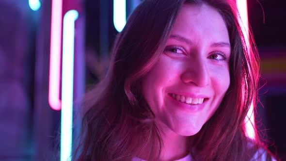 Happy Face of a Woman Close Up in a Neon Light