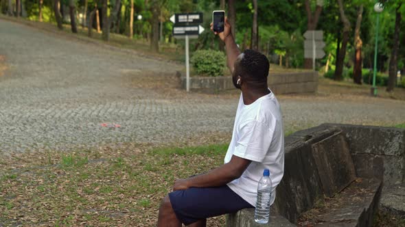 African American Resting in the Park After Jogging and Taking a Selfie