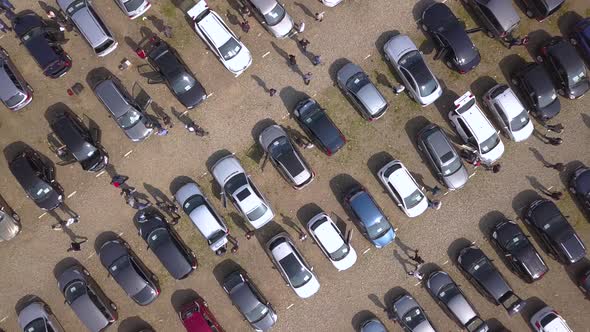 Aerial top view of many cars parked and people customers walking on car market or parking lot alt