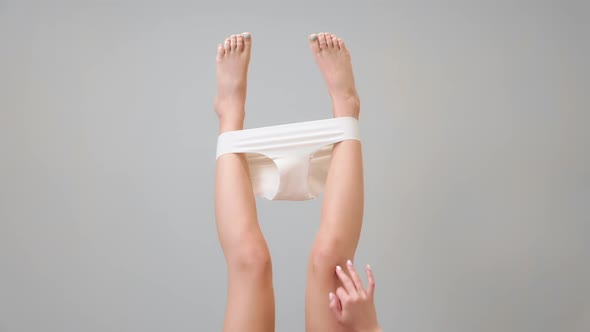 Slender female feet with panties stretched over them. alt