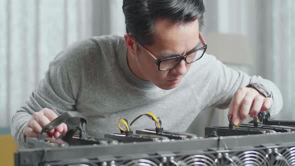 Close Up Of Asian Man Connects The Power Cords Of Mining Rig For Mining Cryptocurrency alt