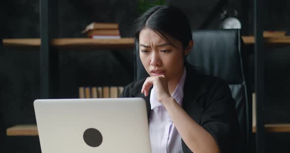 Shocked Asian Businesswoman Upset with Bad Deal Looking at Laptop Screen Reaction on Crisis alt