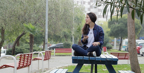 Young Girl Listening to Music in the Park