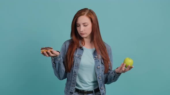 Young Woman Choosing Between Apple and Cupcake the Girl Is Confused in Her Choice alt