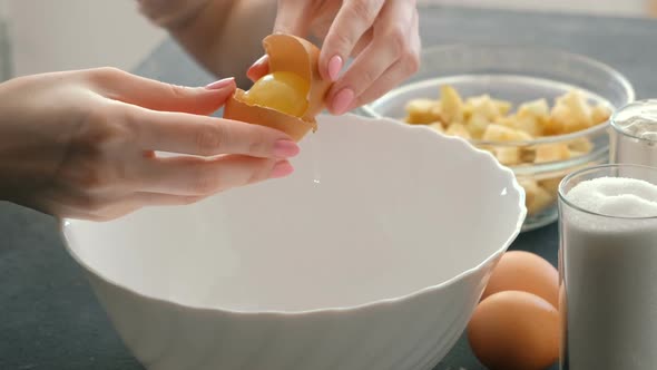  Woman's Hands Break the Egg and Separate the White From the Yolk.
