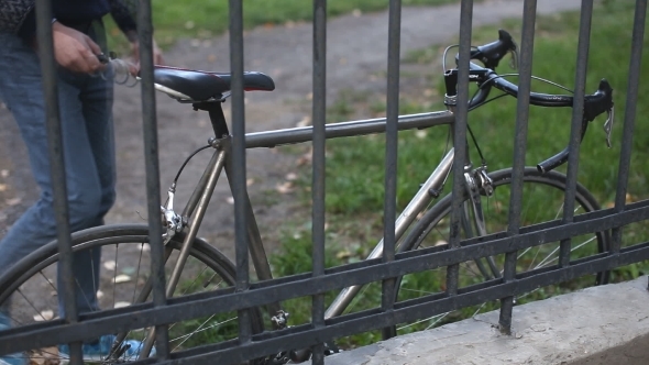 Man Puts The Lock On The Bike alt