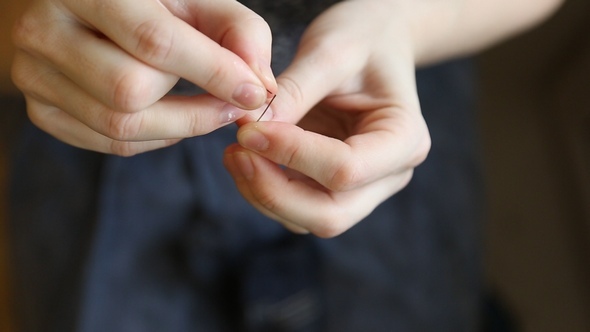 The Woman Inserts the Thread Through the Needle alt