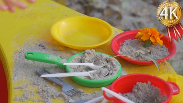 Little Girl Plays With Colorful Plastic Dishes alt