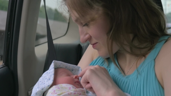 Mother With Newborn Baby In Car alt