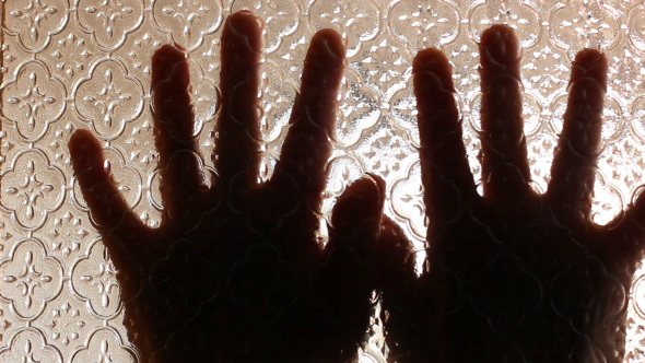 Terrified Hands Of Victim Behind The Glass