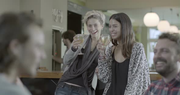 Women enjoying wine and talking in pub