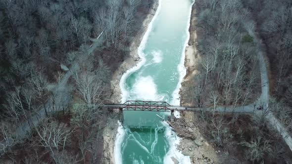 Rusty Footbridge over Icy Mountain River alt