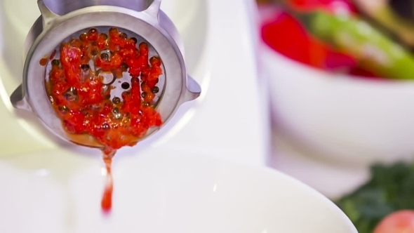 Red Paprika Being Minced Through Grinding Machine