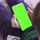 Smartphone in Hand with a Green Screen The Child Is Holding a for Keying Close-up Playing a Game - VideoHive Item for Sale