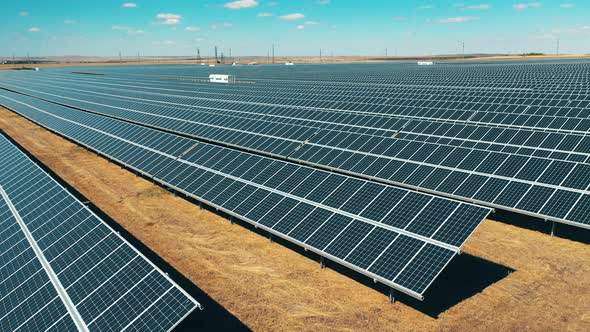 Aerial Shot of a Photovoltaic Power Station Located in a Field alt