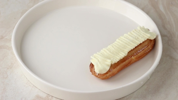 White Plate Of Eclairs With White Butter Cream And