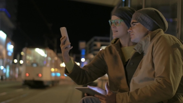 Friends Making Selfie And Using Pad At Tram Stop alt