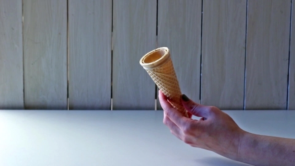 Female Hand Puts Ice Cream In Cone