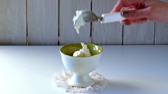 Female Hand Puts Ice Cream In Ceramic Vase