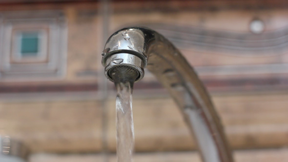 Water Flowing From Metallic Faucet In Bathroom