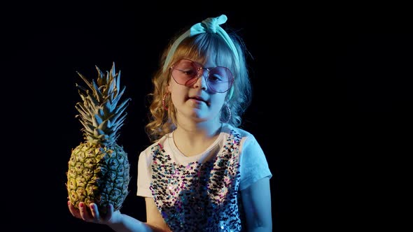 Stylish Teen Caucasian Kid Girl with Pineapple Standing on Black Background Singing Fooling Around alt