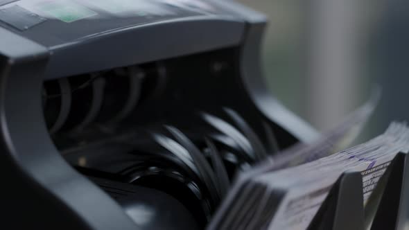 Closeup shot of money counting machine with 100 dollar bills.