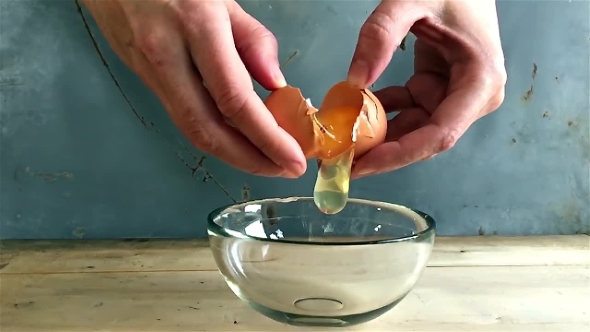 Breaking Eggs In a Glass Bowl