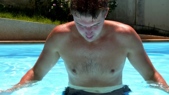 Young Wet Sexy Muscular Man Washing Face In Pool