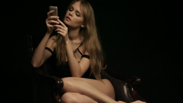 Beautiful Woman In a Chair Sending Sms