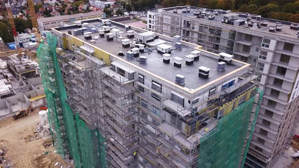 Construction of a residential building. Cranes and constuction site. Drone footage. Drone descending alt